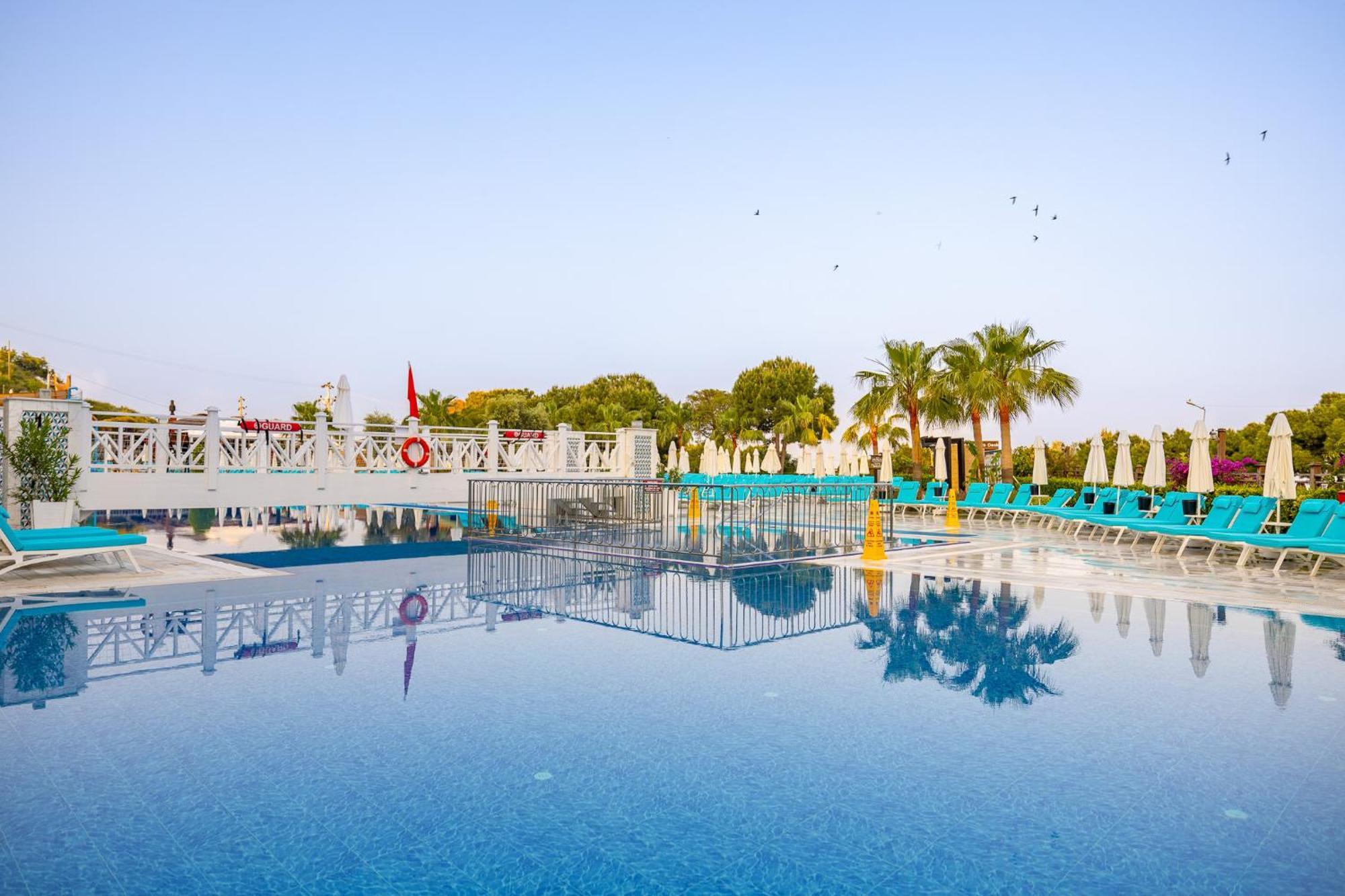 Ramada Resort Kusadasi & Golf Esterno foto A swimming pool at a hotel in Turkey