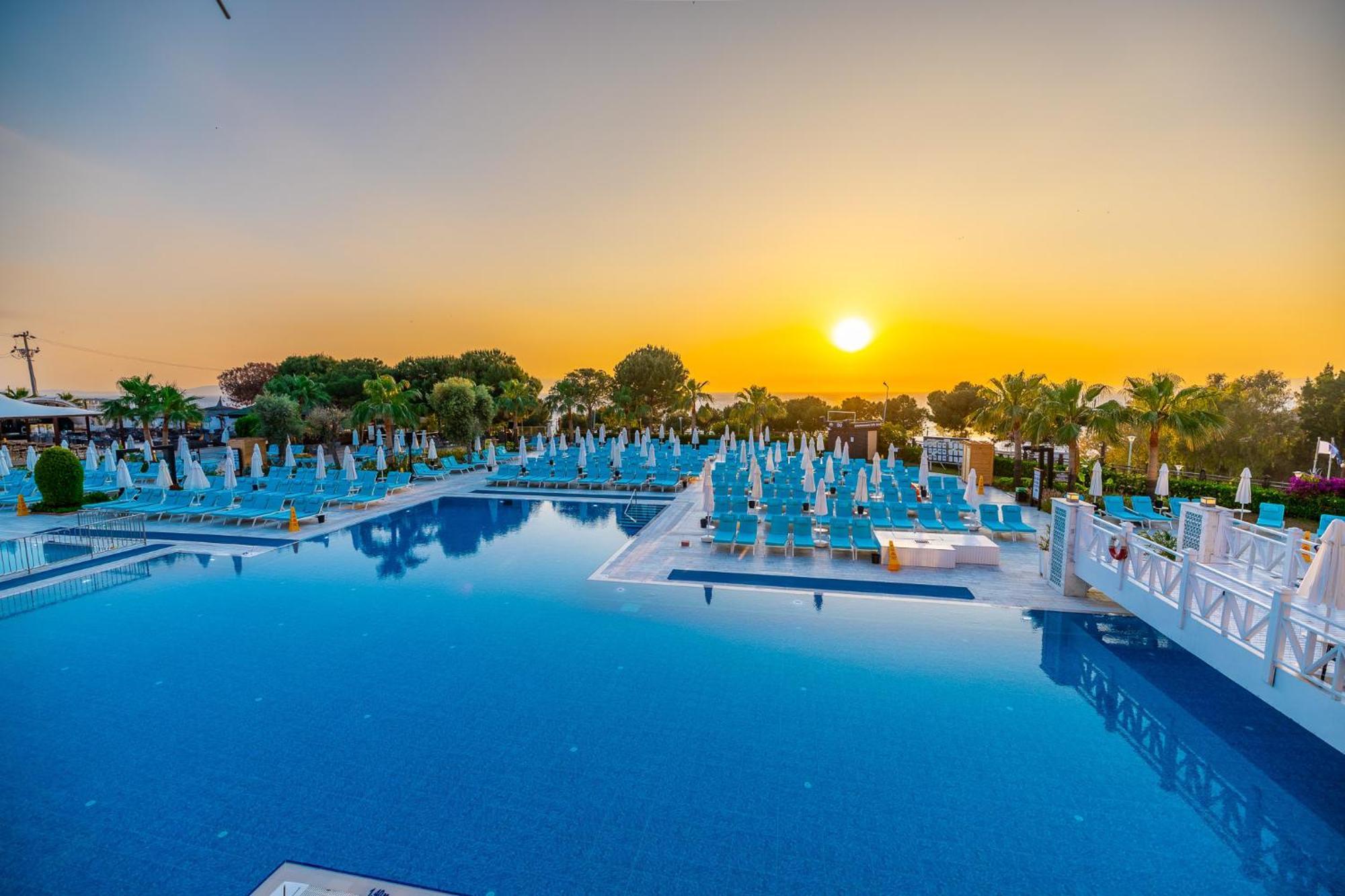 Ramada Resort Kusadasi & Golf Esterno foto Sunset at the pool of the hotel