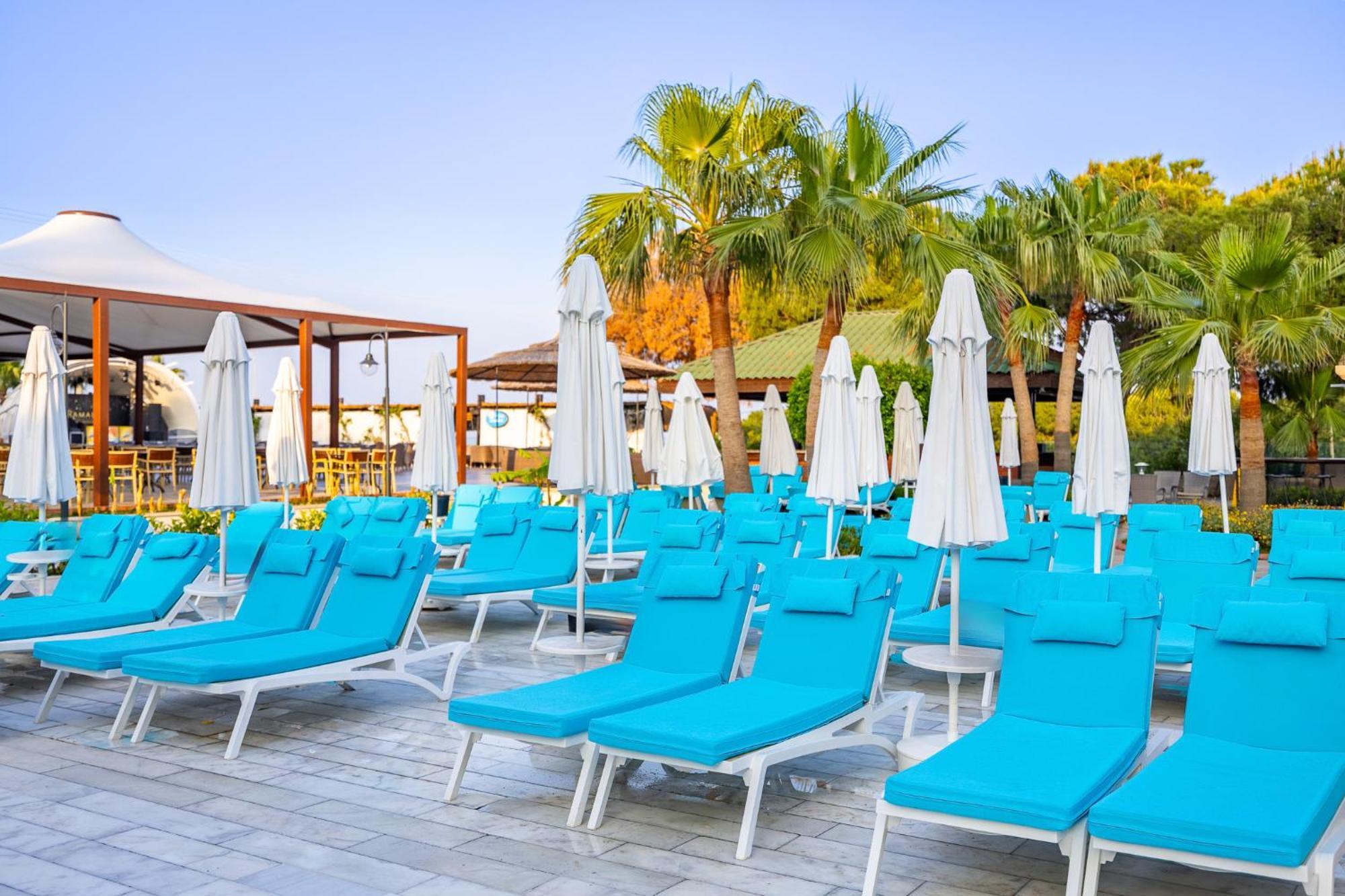 Ramada Resort Kusadasi & Golf Esterno foto Sunloungers at a resort in Turkey